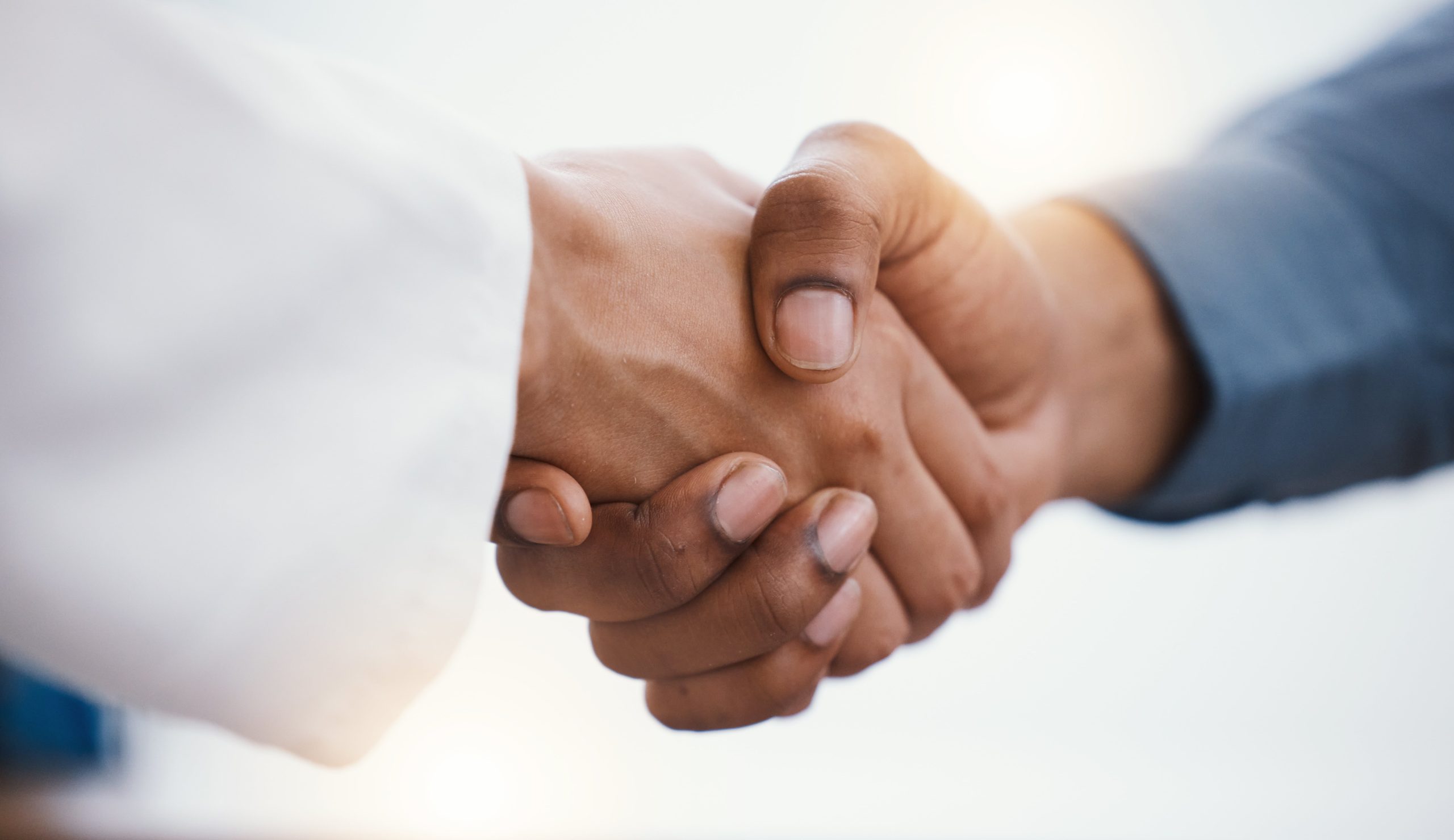 Health, closeup and handshake for partnership, motivation and success with agreement, collaboration and greeting. Zoom, hands and people with teamwork, congratulations and consultation in hospital.