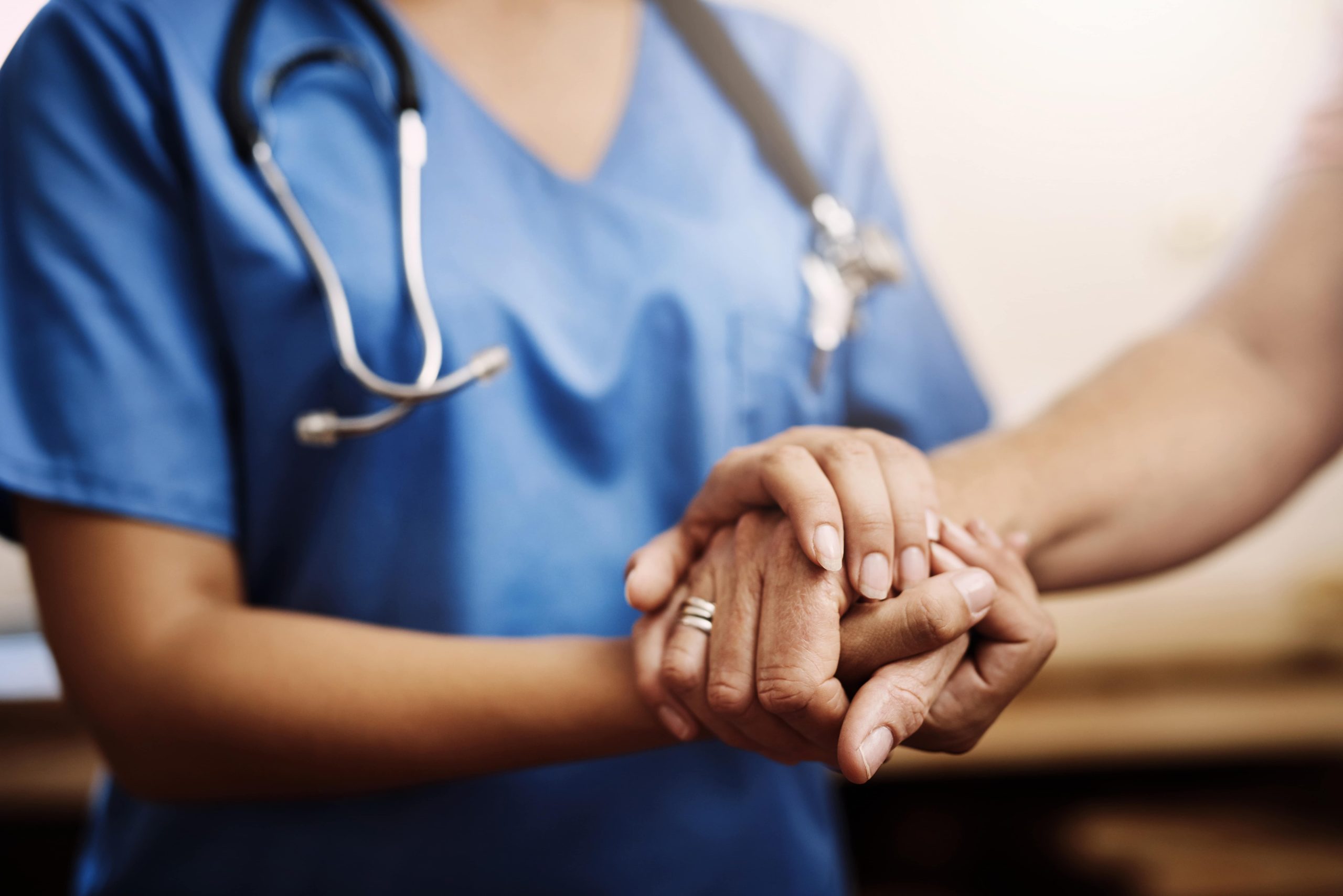 Cropped shot of an unrecognizable female nurse holding a senior womans hands in comfort.
