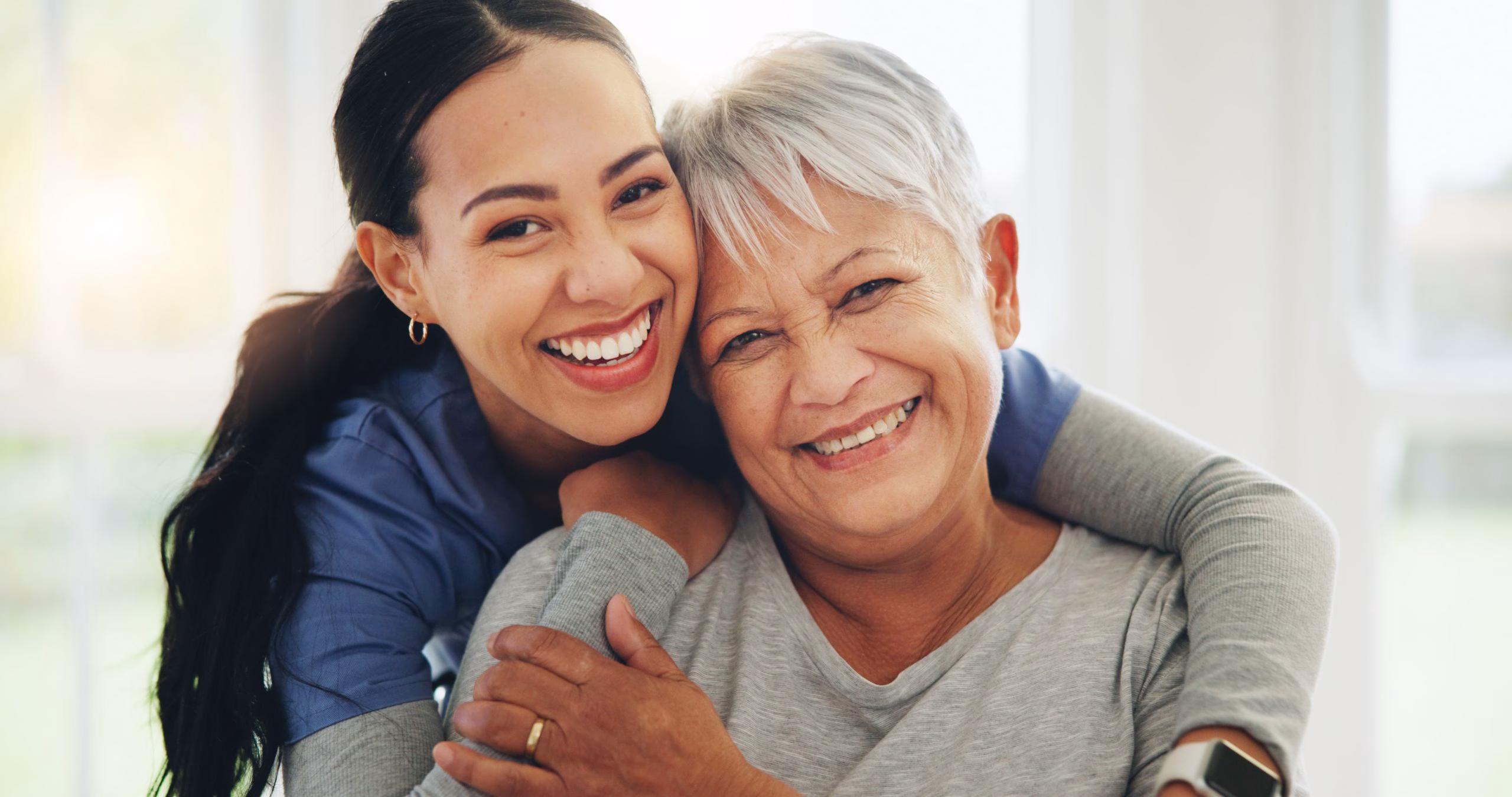Happy woman, nurse and hug senior patient in elderly care, support or trust at old age home. Portrait of mature female person, doctor or medical caregiver hugging with smile for embrace at house.